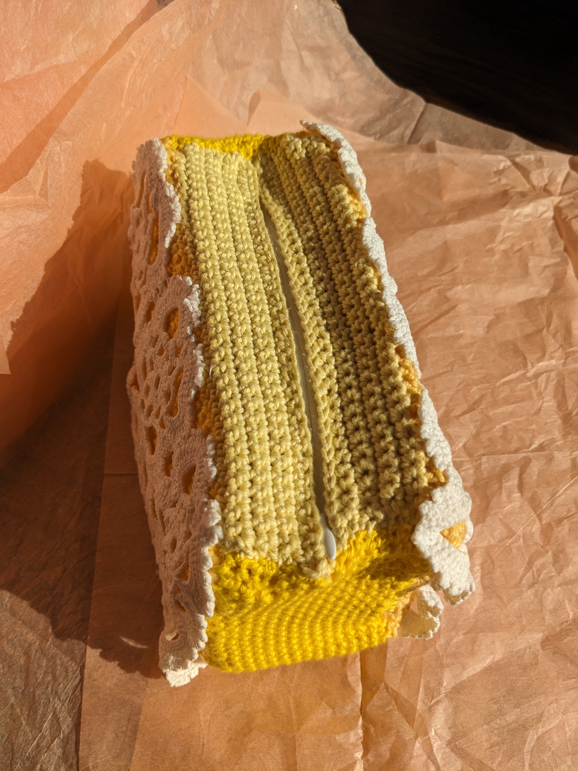 Crocheted yellow and white ucpcycled vanity bag on a textured surface