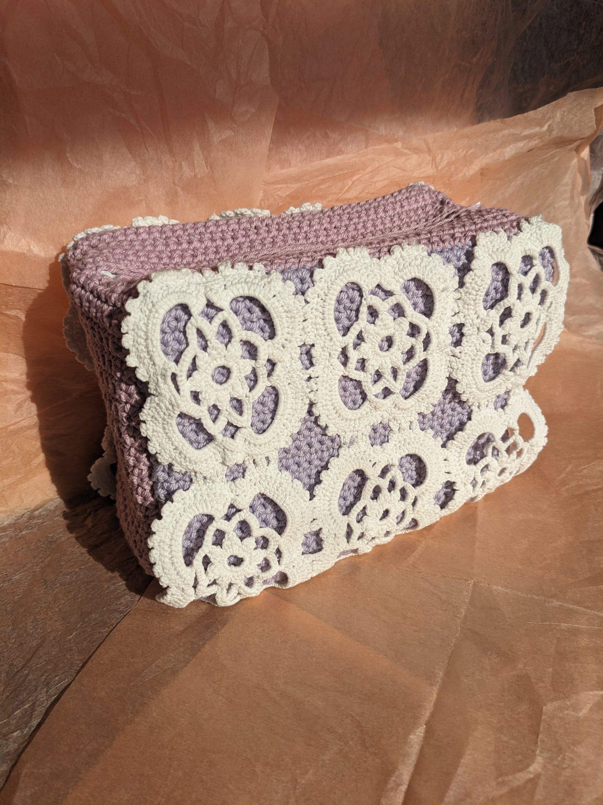 Upcycled crochet vanity bag with lace detailing on a pink surface