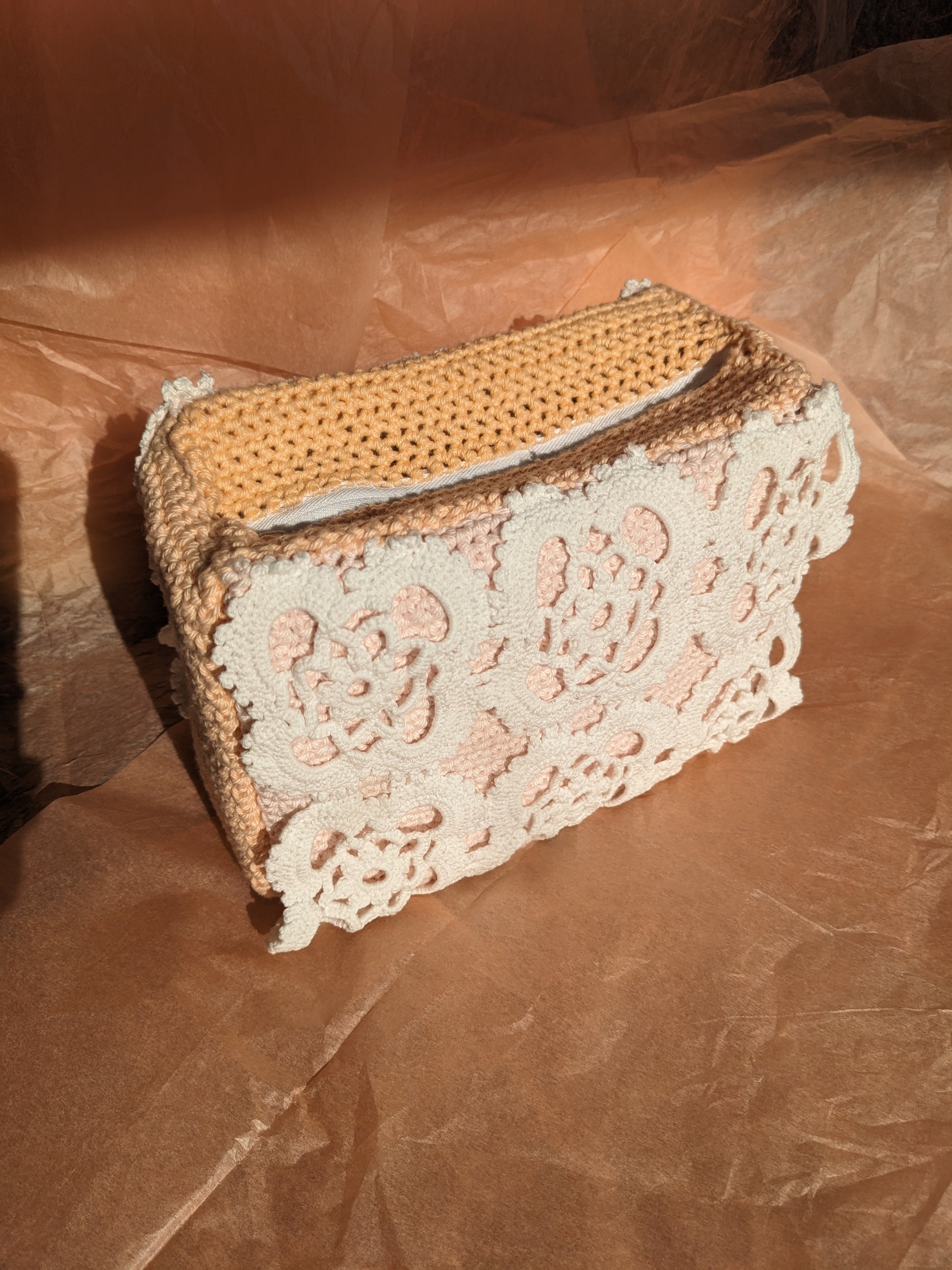 Upcycled crochet vanity bag on a textured pink background
