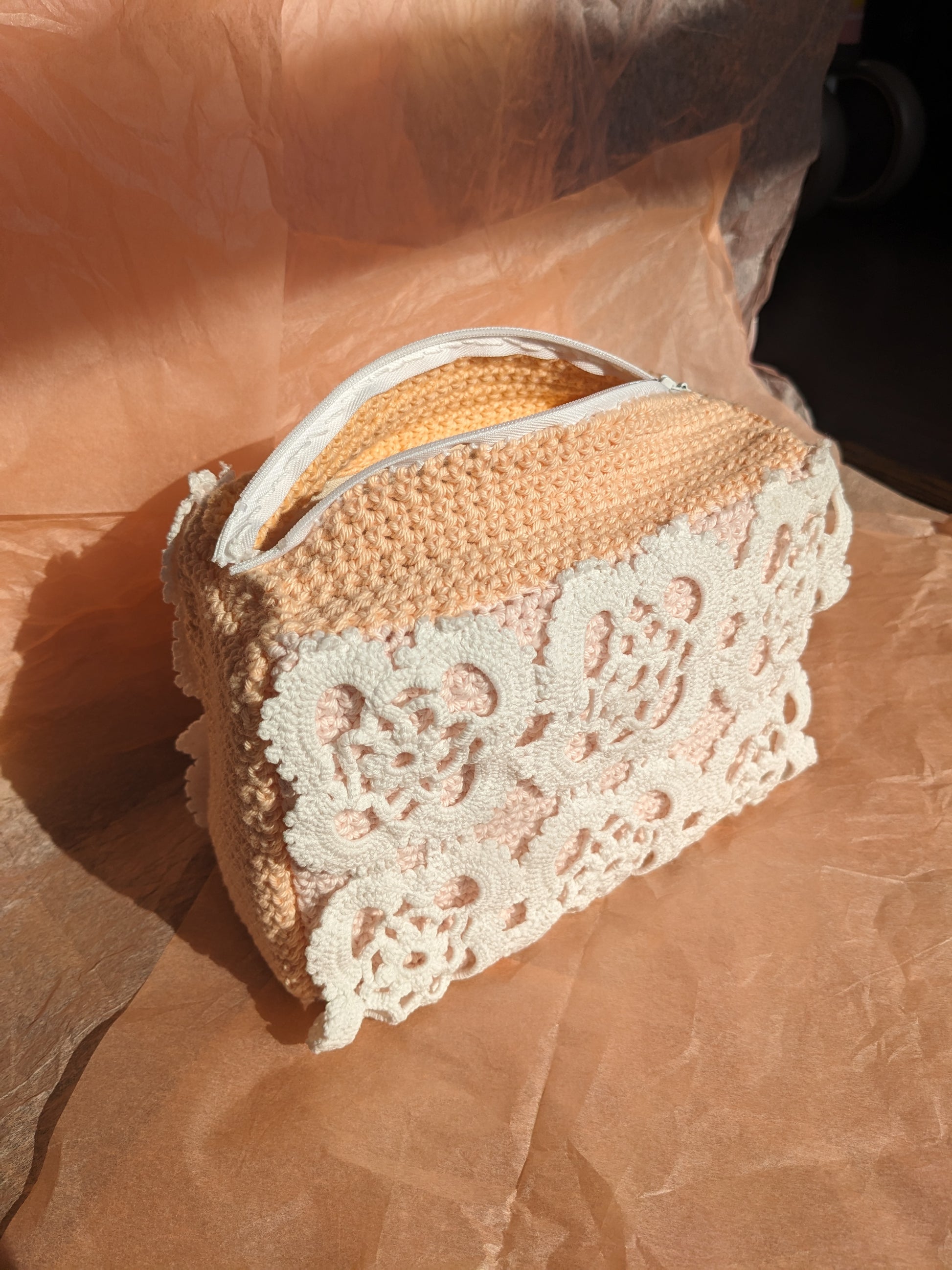 Upcycled crochet vanity bag on textured pink background