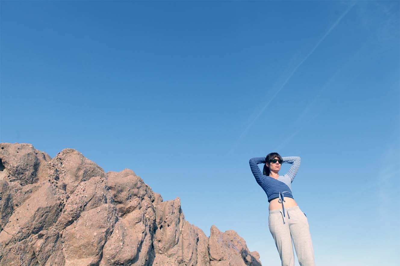 Model wearing the surena crochet ballerina wrap top in navy and baby blue, a handmade crochet top made with cotton yarn.