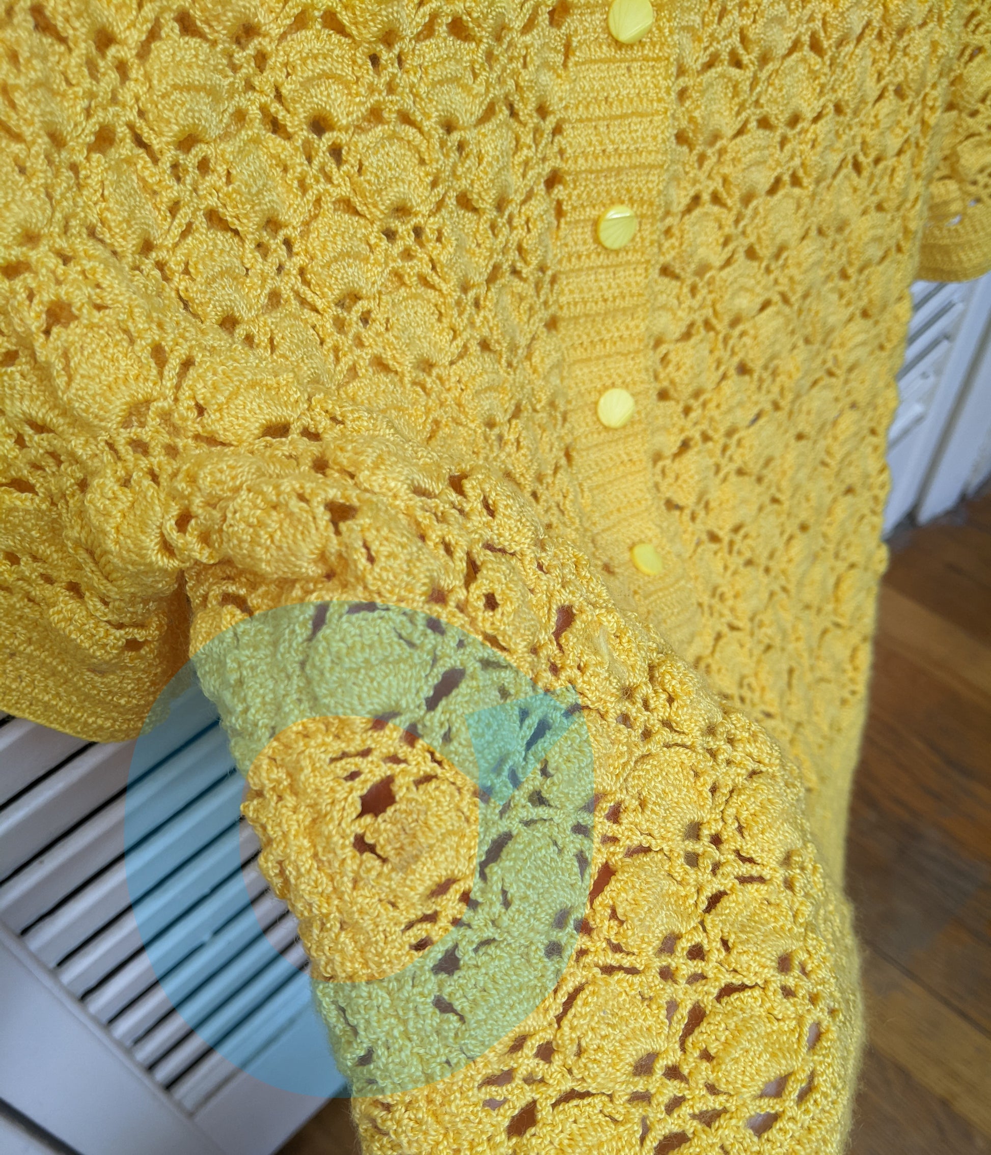 Detail on small blemish on the surena crochet "preloved" collection yellow sunshine cardigan.