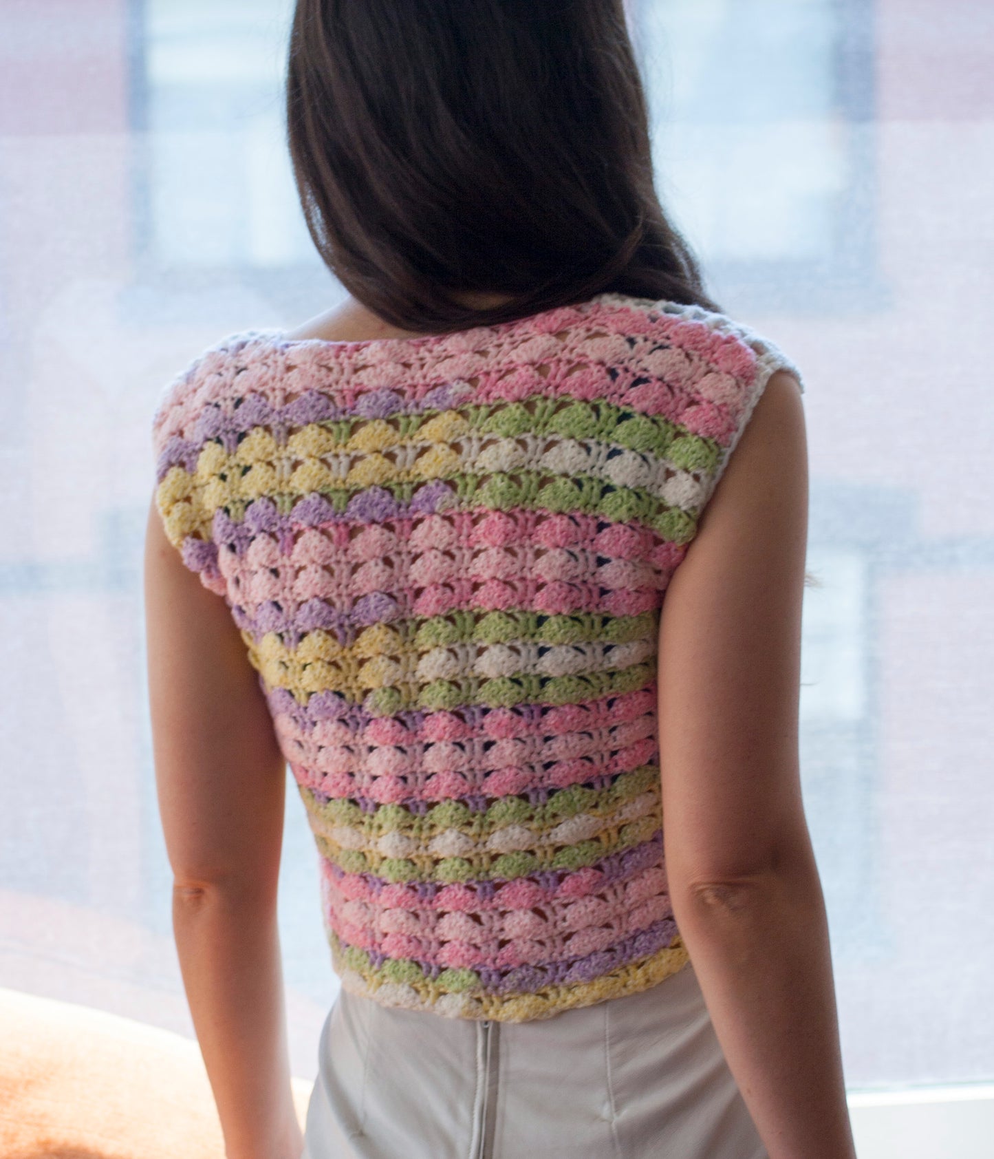 Back of the pastel rainbow crochet mini top, as worn by the model