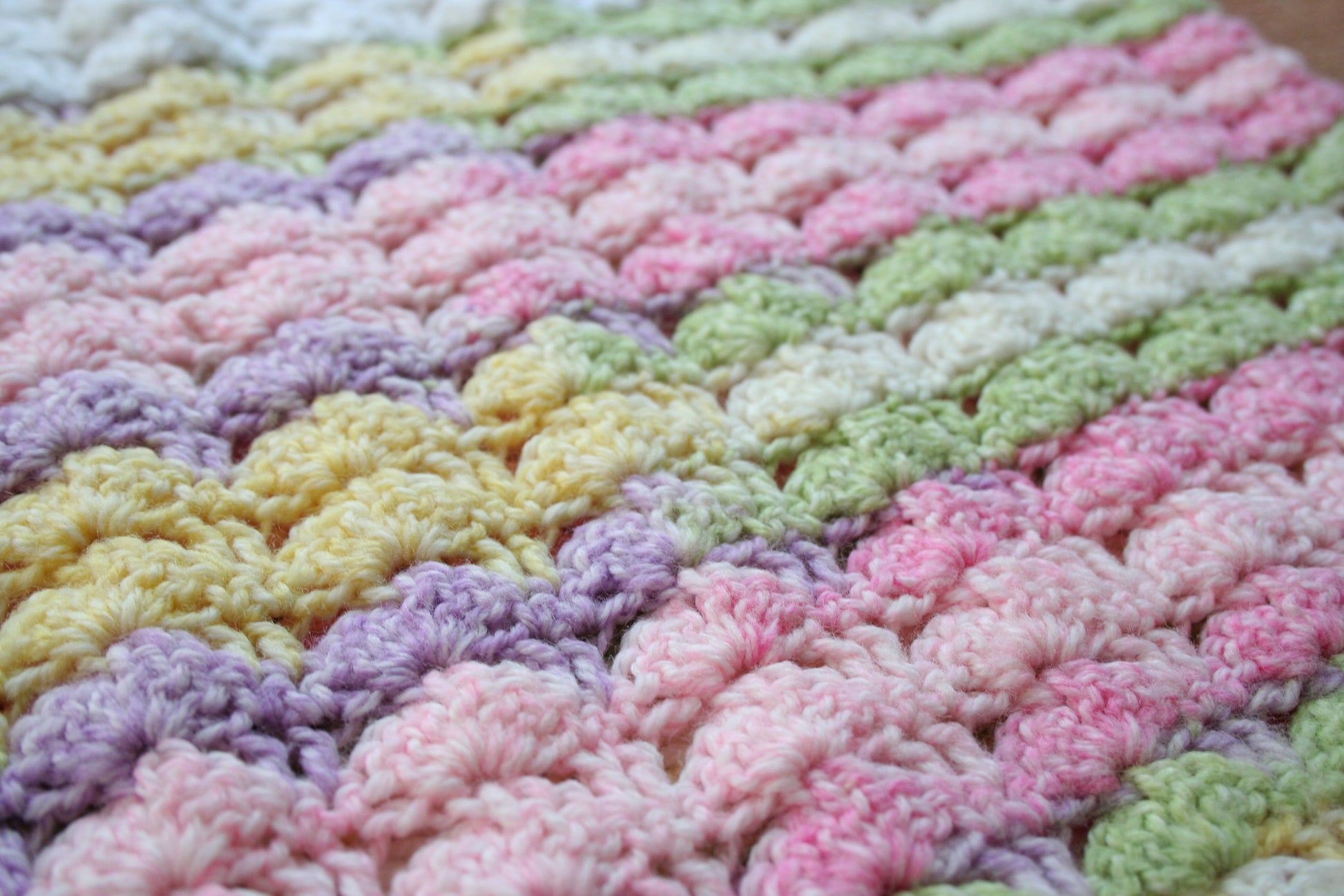Detail of the crochet stitch pattern in the preloved pastel rainbow mini top