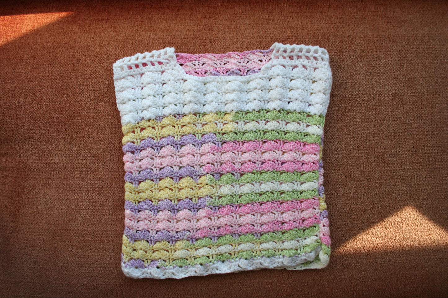 Pastel rainbow crochet mini top laid flat