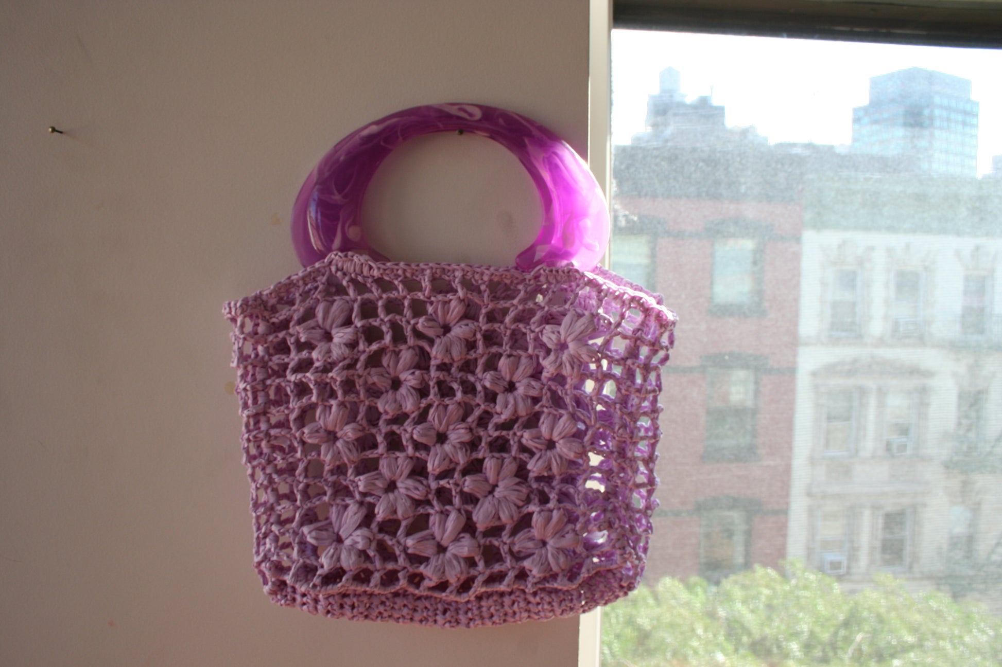 The Jazmín crochet raffia bag hung on the wall