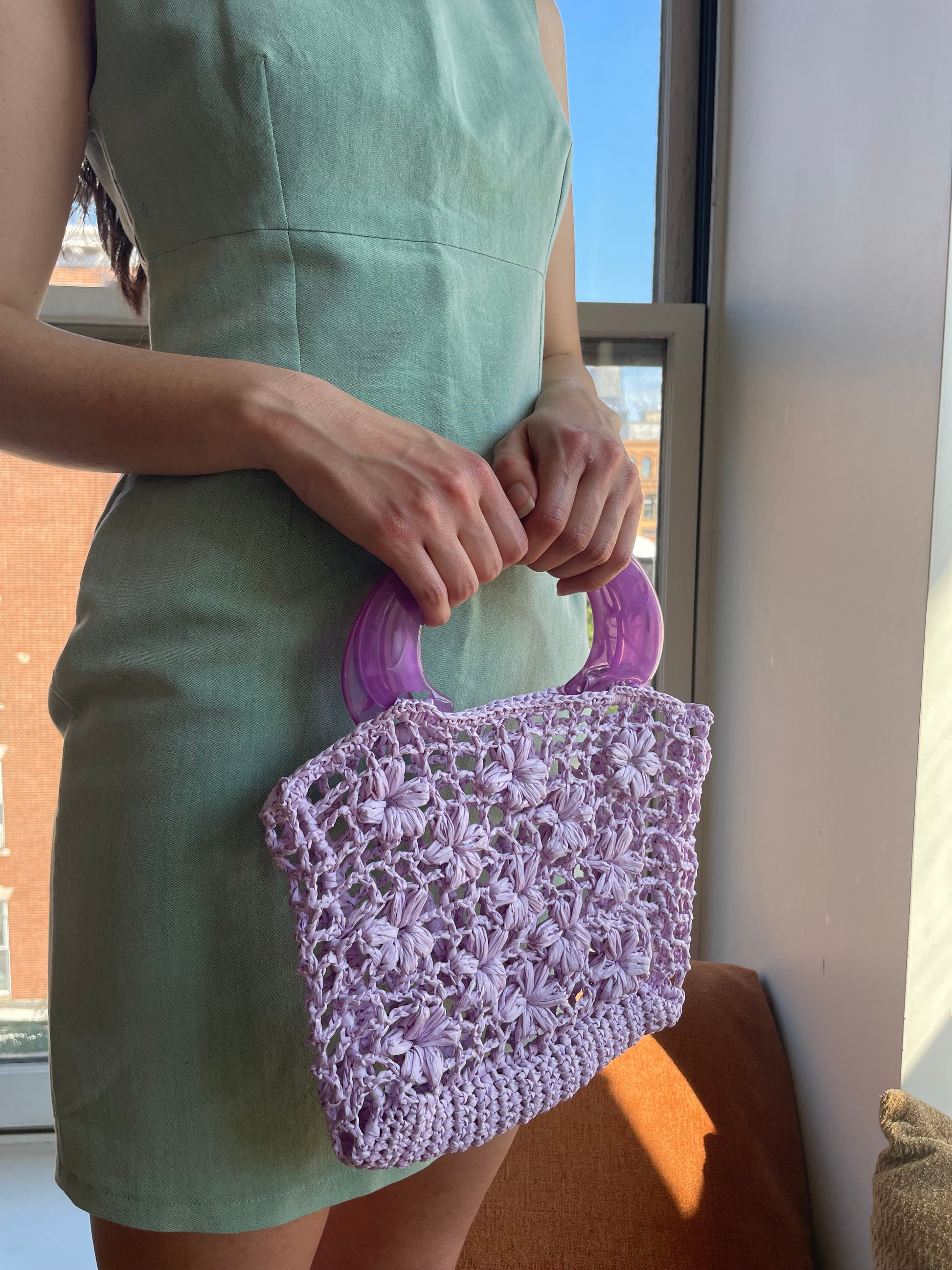 Model wearing the jazmín crochet raffia bag in lilac