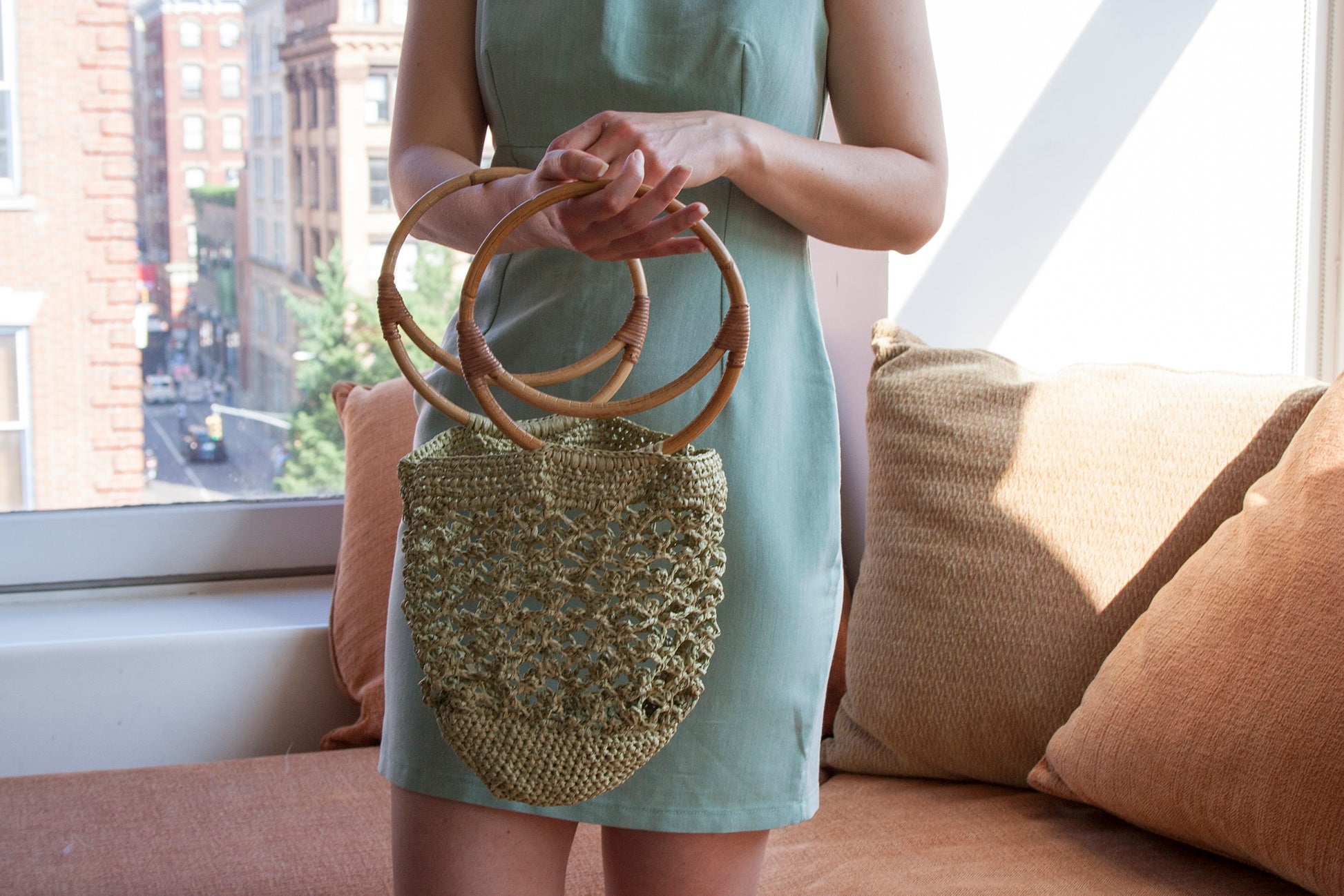 Model holding the Piña raffia bag in green
