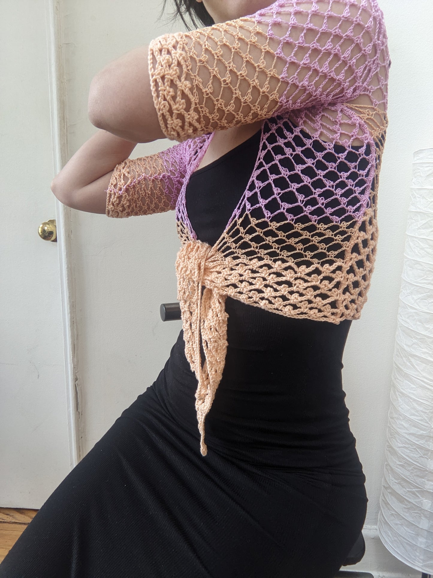 Model wearing the Surena Crochet Sirena top in "dawn" purple and salmon 