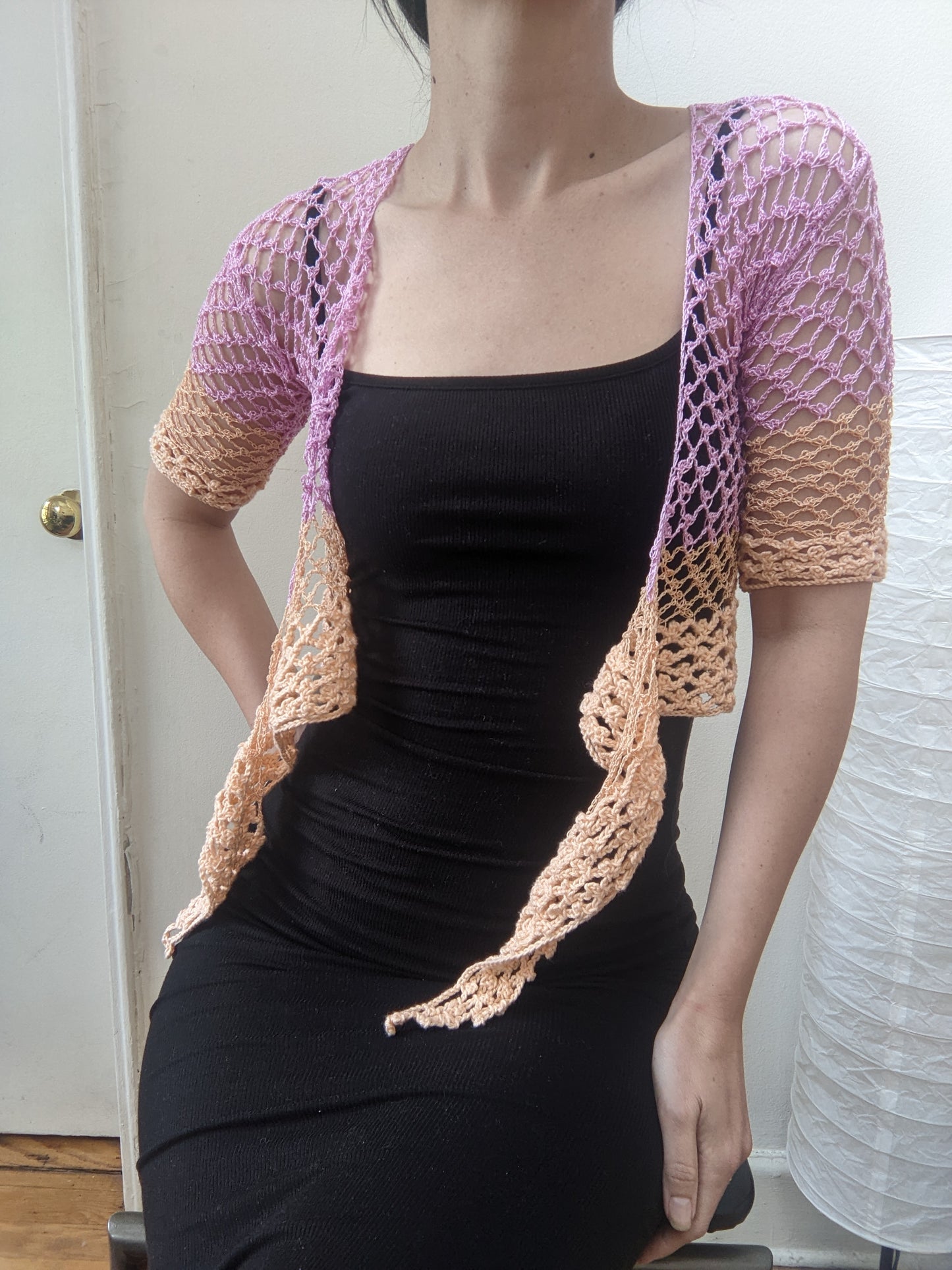 Model wearing the Surena Crochet sirena crochet top in "dawn" purple and salmon