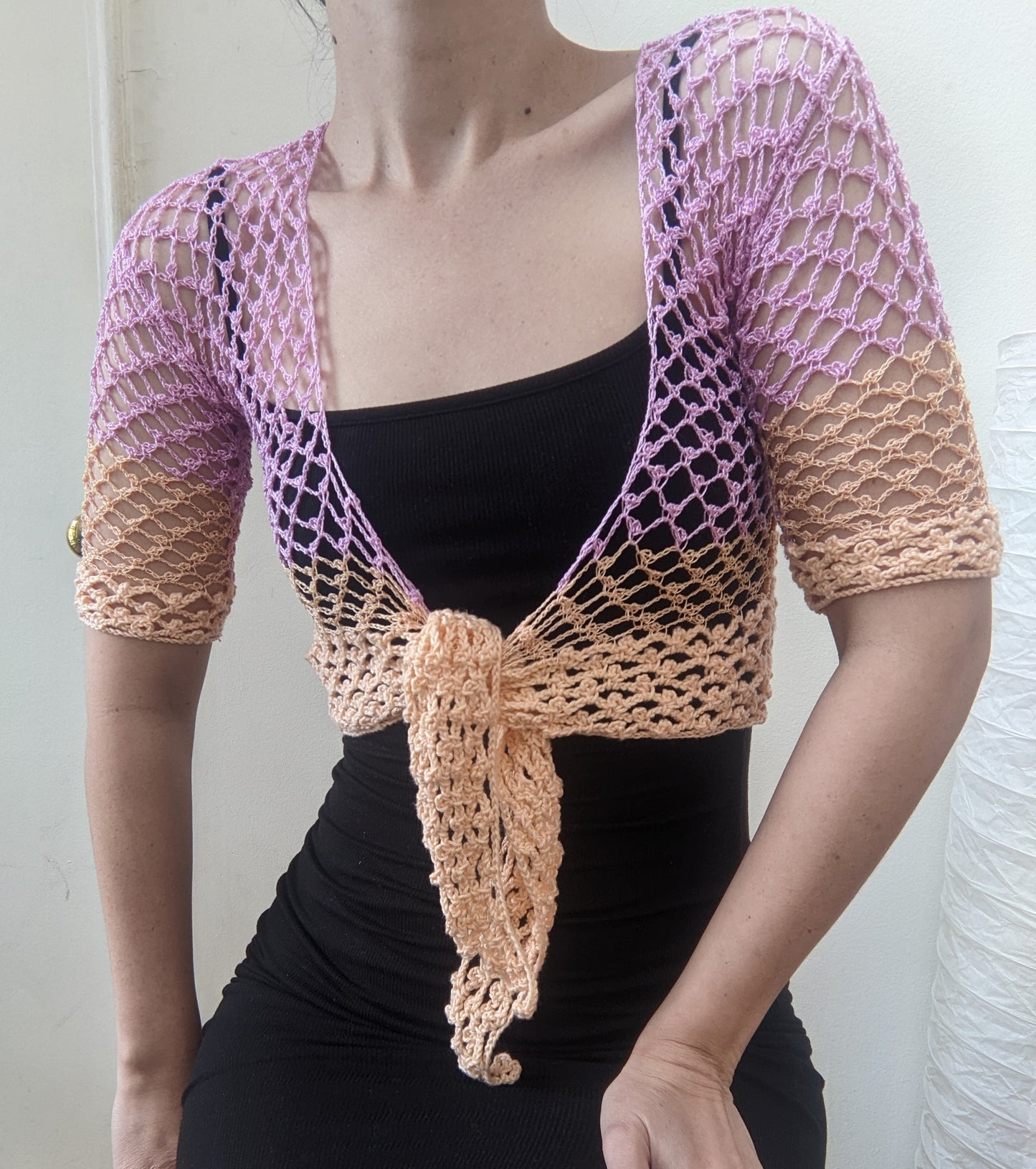 Model wearing the Surena Crochet sirena crochet top in "dawn" purple and salmon