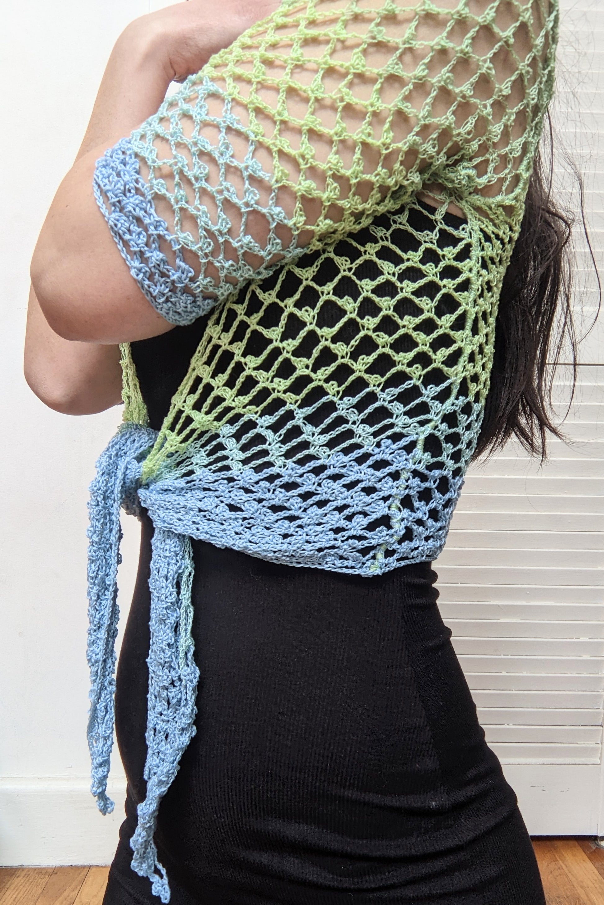 Model wearing the Surena crochet sirena crochet top in "ocean" blue and green color palette, handmade with cotton yarn