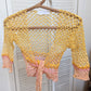 Detail of the Surena crochet sirena crochet top in "sunset" yellow and pink color palette