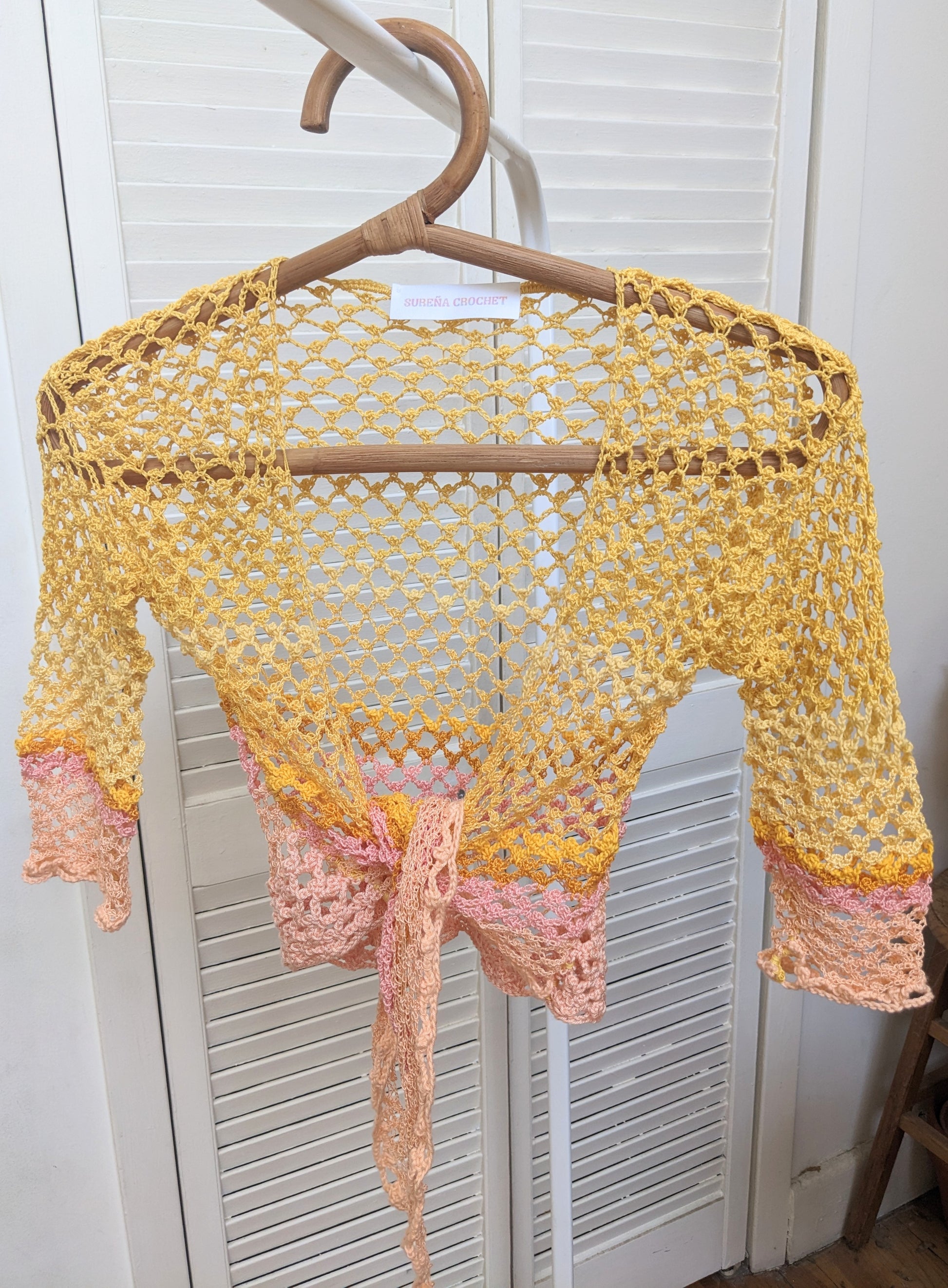 Detail of the Surena crochet sirena crochet top in "sunset" yellow and pink color palette