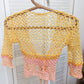 Detail of the Surena Crochet Sirena crochet top in "sunset" yellow and pink color palette