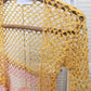 Detail of the Surena Crochet Sirena crochet top in "sunset" yellow and pink color palette