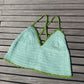 Detail of the surena crochet croptop in mint and green, paid flat. Handmade with cotton yarn, a perfect summery croptop
