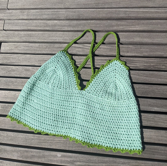 Detail of the surena crochet croptop in mint and green, paid flat. Handmade with cotton yarn, a perfect summery croptop