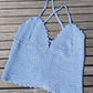 Detail of the surena crochet estrella croptop in baby blue, laid flat. Handmade summery croptop using cotton yarn.