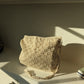 Beige crochet bag laid flat on white surface