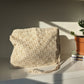 Beige crochet bag laid flat on white surface