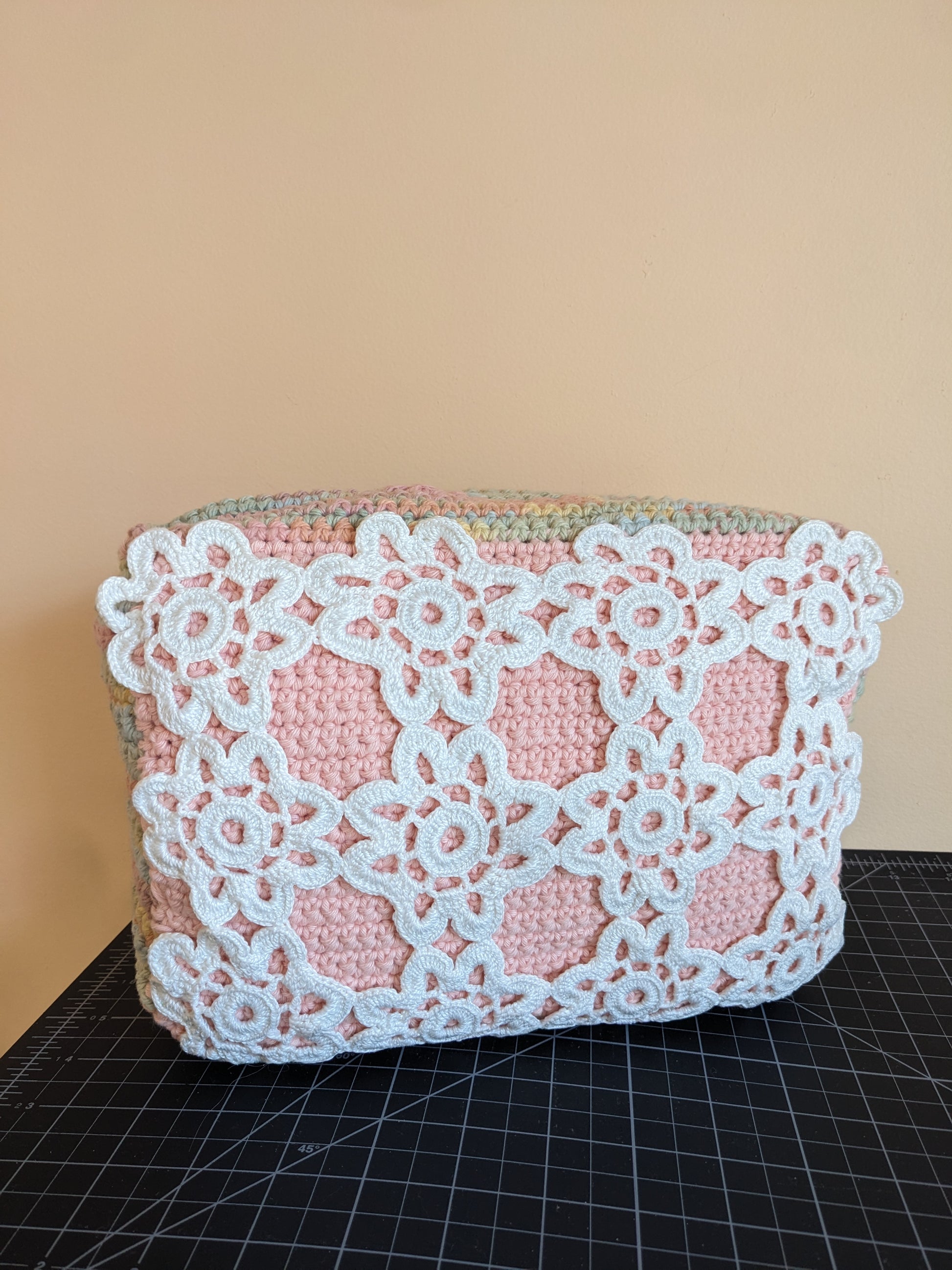 Upcycled crochet vanity bag with lace detailing on a pink surface