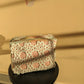 Crocheted pouch with floral pattern on a black stool against a salmon wall.
