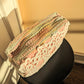 Upcycled crochet pink and rainbow clutch on a black stool against a white and salmon background