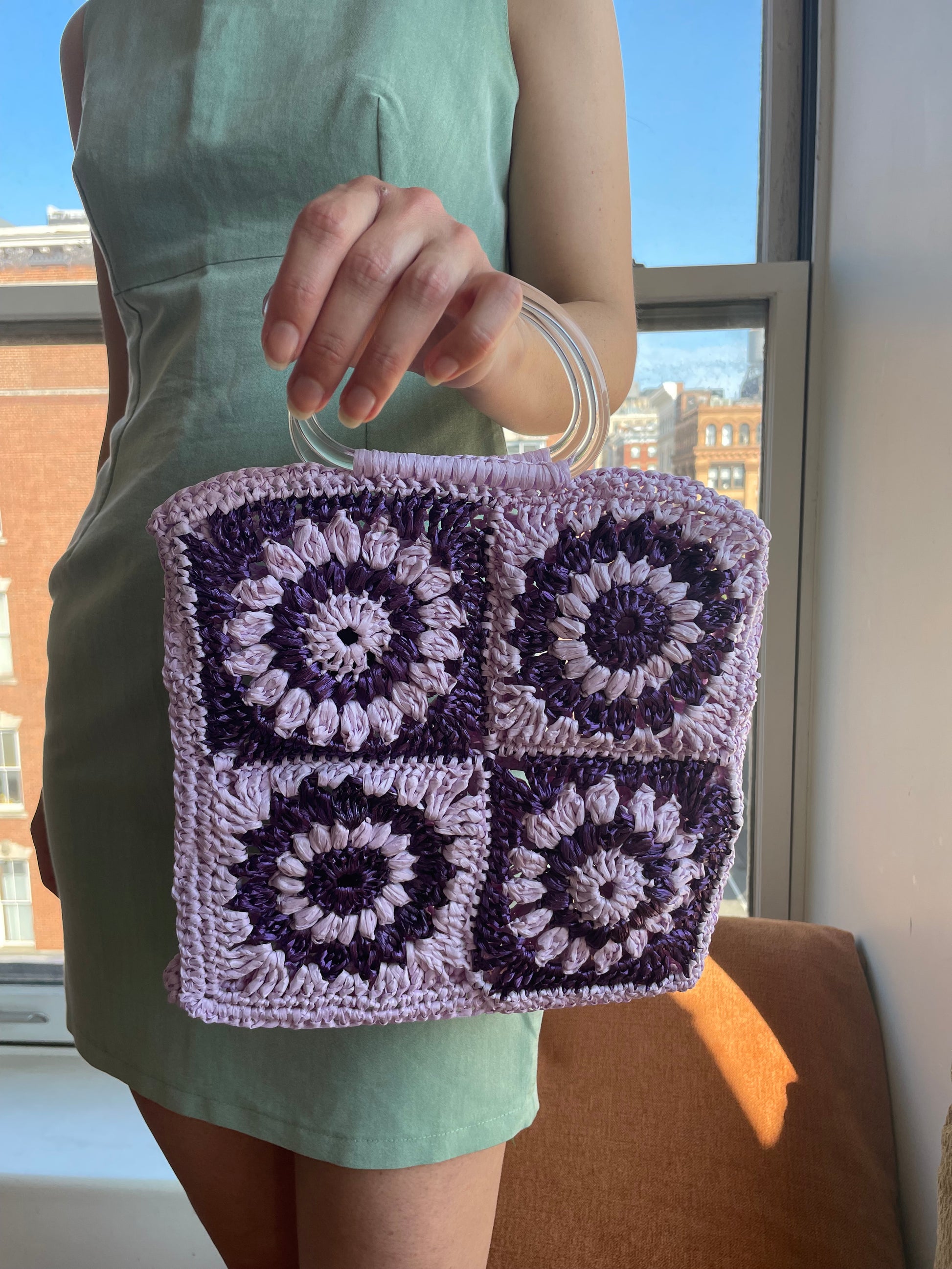 Model holding the granny square frame bag (one of the sides)
