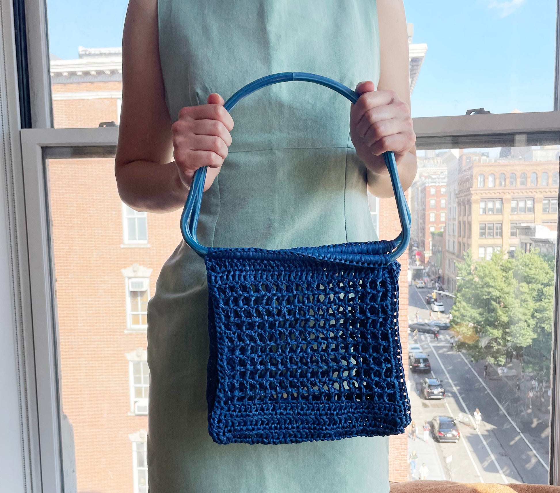 Model holding the blue market raffia bag