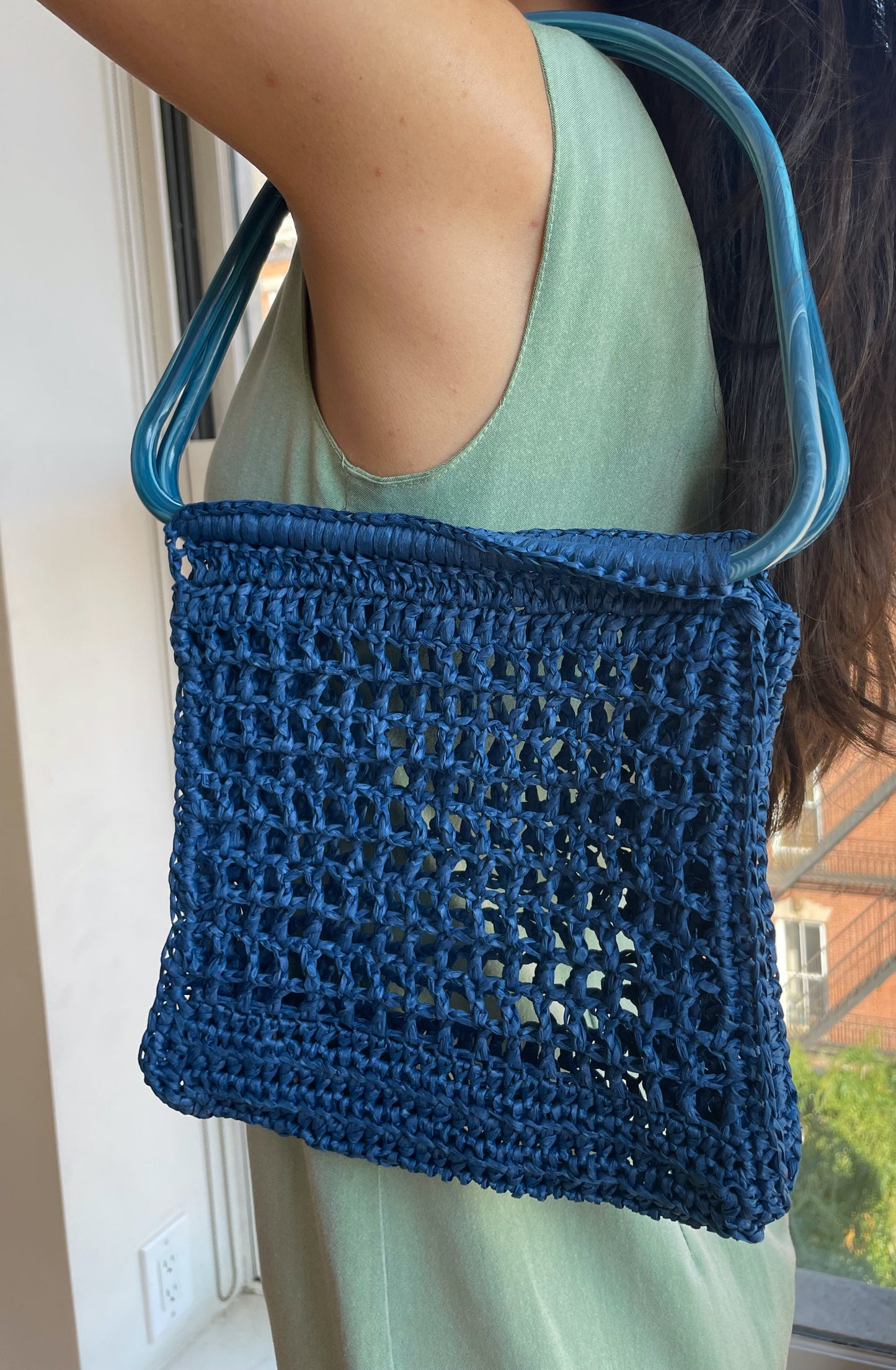 Model wearing the blue market raffia bag on the shoulder 