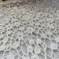 Detail photo of the white crochet beaded shirt, showing the flower crochet pattern
