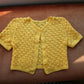 Sunshine yellow crochet cardigan laid flat 