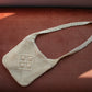 Second hand vanilla crossbody macrame bag laid flat 