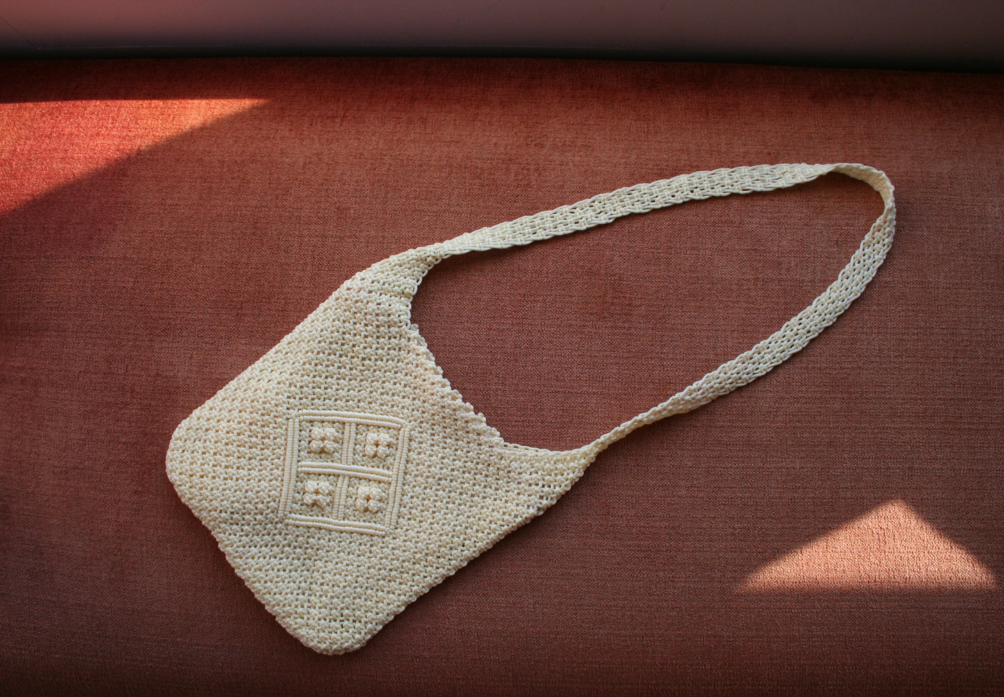 Second hand vanilla crossbody macrame bag laid flat 