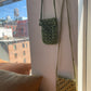 The two crossbody raffia bags hung on the wall 