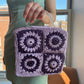Model holding the granny square raffia crochet bag in lilac