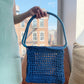 Model holding the market raffia bag in blue