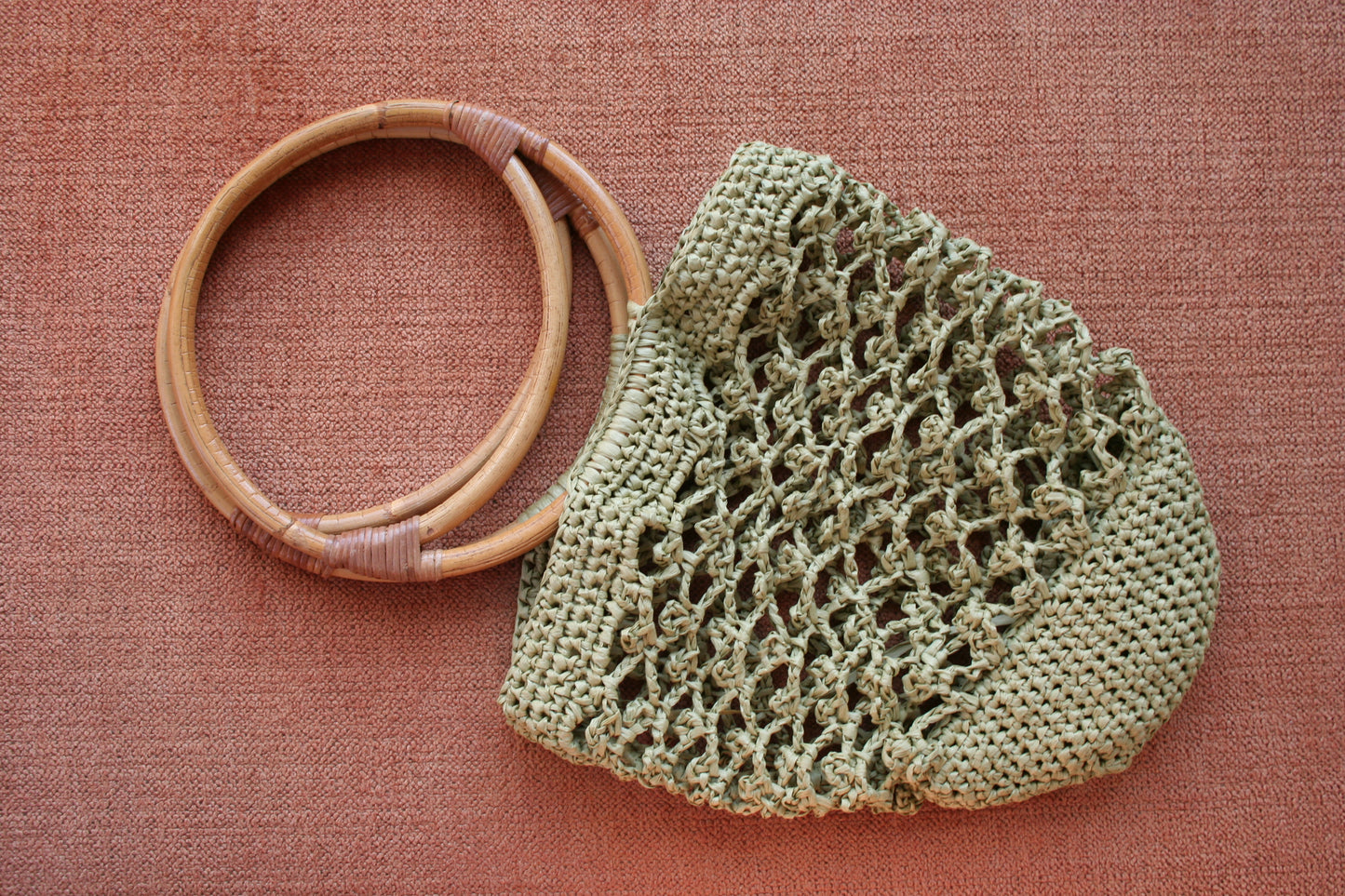 Piña raffia bag in green laid flat 